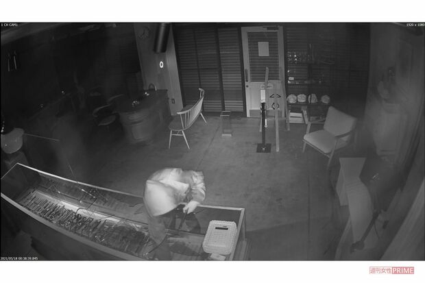 ショーケース内に手を突っ込む（江口時計店提供）5/8