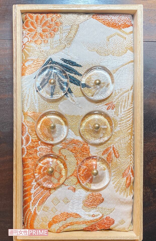 金運を呼ぶゴールド系の生地に水晶のボタンを並べたスマホベッドは、富士川さんオリジナル