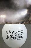ライブ演出の花火の煙が上空に立ち込める『神宮球場』のスタンド(上)と、フリマアプリの『メルカリ』にも出品されていた『アラフェス』ロゴ入りの風船(下)