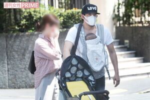 新しく生まれた子どもを抱っこひもで抱え家族全員で外出する加藤（その２）