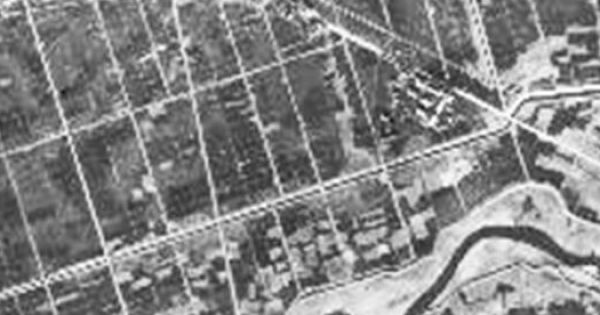  昭和21年ごろ米軍がB29から空撮した当時の『パークシティLaLa横浜』付近の様子（写真は高橋教授提供）。白の太線が現在、マンションがあるあたりで白い点線一帯は鶴見川の後背湿地。点線内を中心に色が黒い部分は鶴見川の支流が流れていた特に低湿で軟弱な湿田