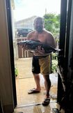 アマゾンの大型魚をプールに移す江口容疑者(本人のSNSより)