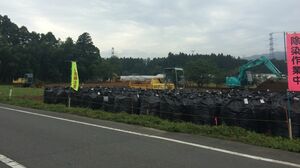 除染作業中の看板近くに放射能汚染ゴミを入れたフレコンバッグが並ぶ（楢葉町）