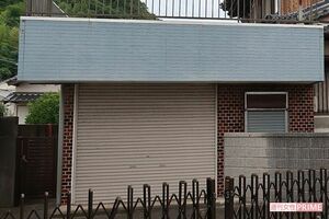 シャッターの閉まった建物の奥に松本博和さんと妻の満喜枝さんの遺体が入った業務用冷蔵庫が見つかった