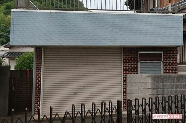 シャッターの閉まった建物の奥に松本博和さんと妻の満喜枝さんの遺体が入った業務用冷蔵庫が見つかった