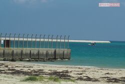 水平線に浮かぶ辺野古の埋め立て予定地の護岸の一部。手前は米軍基地のフェンス