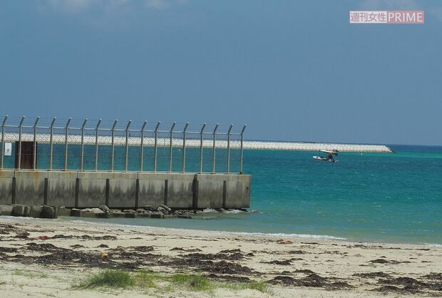 水平線に浮かぶ辺野古の埋め立て予定地の護岸の一部。手前は米軍基地のフェンス