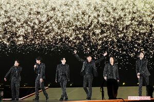 黒の衣装を纏い、華やかなステージで歌うV6のメンバー