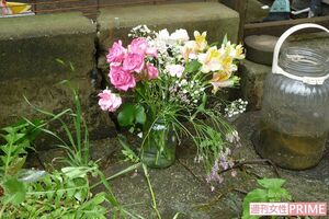 遺体が見つかった住居兼店舗には淡い色の花（切り込み）が手向けられていた