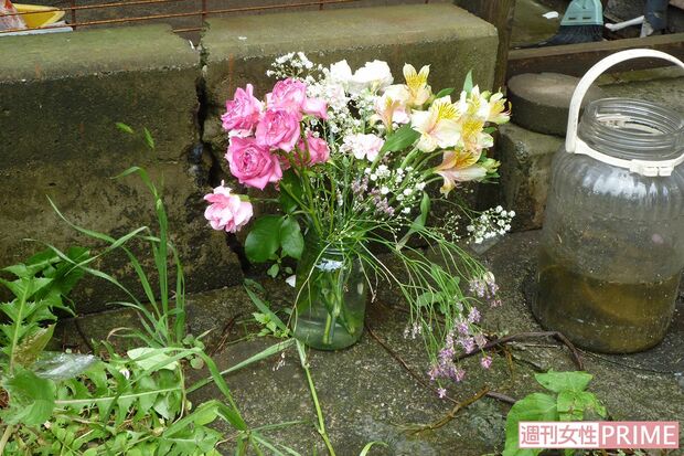 遺体が見つかった住居兼店舗には淡い色の花（切り込み）が手向けられていた
