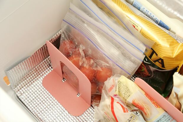 【R】ブックエンドを使い立てて収納。保存袋はカゴに入れると、中身の増減でムダなスペースが生まれることがあるので、ブックエンドで仕切るのが◎。「より冷えが回る、金属製のものがいいですね！」