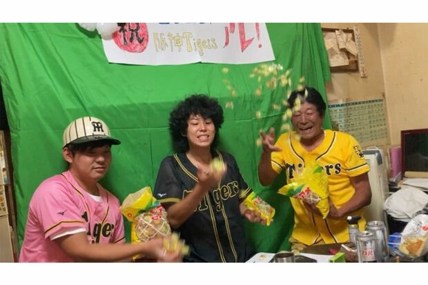 阪神の優勝を次男の虎太郎と喜ぶダンカン。岡田監督がよく舐めている『パインアメ』をかけ合う（ダンカン公式ブログより）