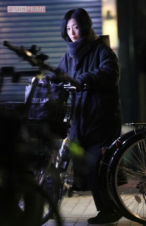 電動自転車に乗り、行きつけの銭湯を後にする壇蜜。ベンチコート姿でもどことなく色っぽい