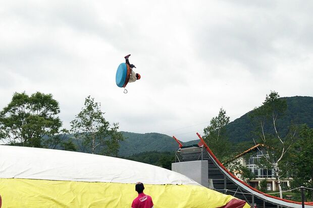 エアチューブに乗り、約12メートルの高さから滑りおりて空に向かって「トビダス」