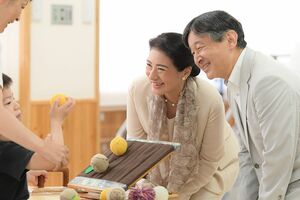 『粕屋新光園』で右手を上手に動かす訓練をする子どもを笑顔で優しく見守られたご夫妻(9月25日)