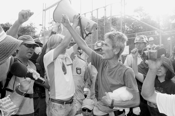 7月1日にヘリパッドへの進入路等の補強工事が始まりゲート前で抗議する市民　(c)沖縄タイムス／共同通信イメージズ
