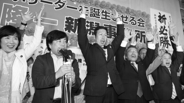当選を決めて万歳する米山氏（中央）。民意は原発再稼働を拒んだ＝16日夜、新潟市内