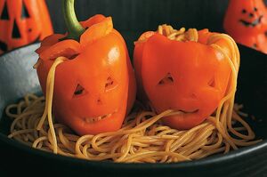 【パプリカのジャックオーランタン】かぼちゃ以外でもジャックオーランタンが楽しめる。パプリカの底を切って安定させ、へたから1cmのところを切る。中にトマト味のパスタを詰める。目や口の穴からパスタを引き出すと怖さ倍増。　『可愛くって ホラーで 美味しい！ キモめし』より