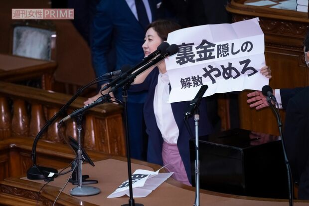 総理大臣指名選挙の投票中、突如壇上で「裏金隠しの解散やめろ」と書かれた紙を掲げる大石あきこ氏(2024年10月1日、週刊女性写真班)