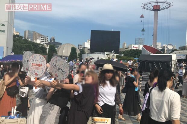 うちわを掲げて撮影するファン／著者撮影