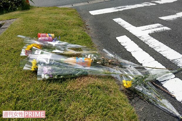 内山茉由子さんが連れ去られた駐車場には花や飲み物が供えられていた