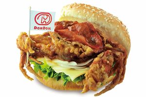旗を持たせるなど演出が濃い公式ビジュアル『ドムドムバーガー』の丸ごとカニバーガー