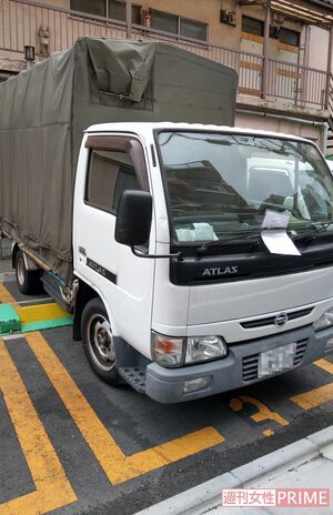 パーキングに駐車されたトラックには色とりどりの花が積まれ、ワイパーには警告書が挟まれていた