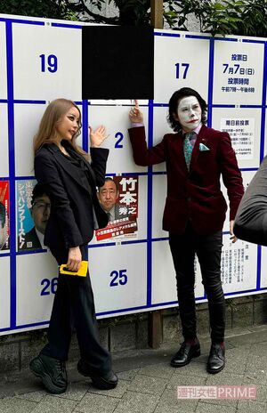 桜井MIU（左）の局部を河合氏（右）の顔で隠した選挙ポスターの前で記念撮影をする2人（画像は河合氏提供）＊ポスター部分は編集部で処理済み