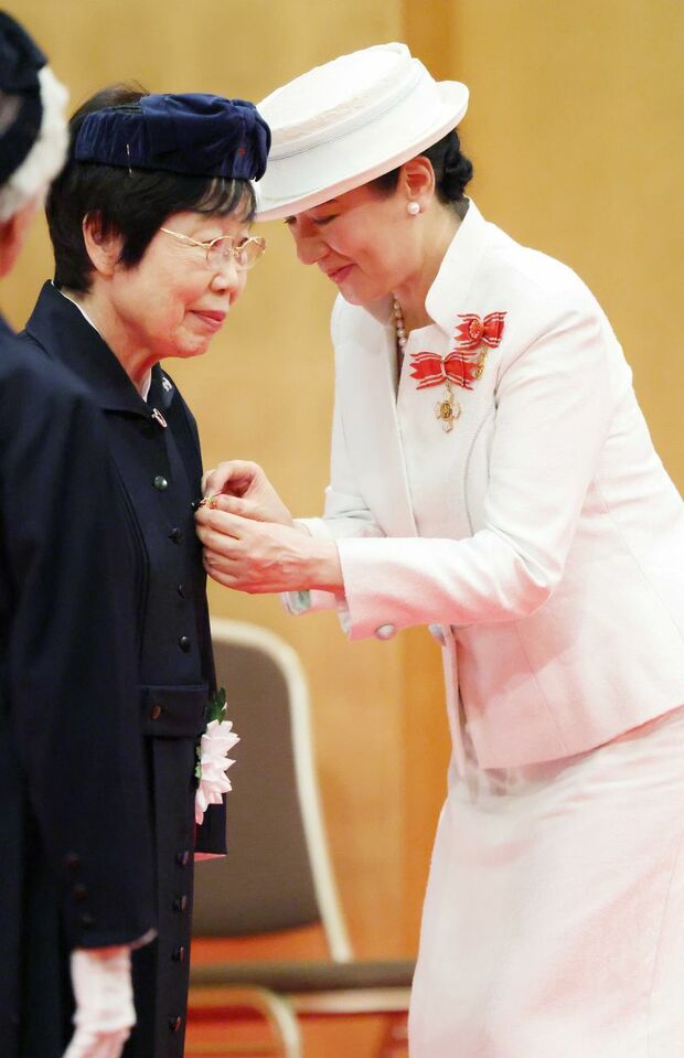 受章者の春山典子さんに、腰をかがめて記章を授ける雅子さま(7月31日)