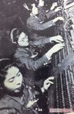 手元の機械に敵機の情報を入力する女子通信隊員
