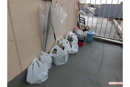 容疑者の自宅マンション前には空き瓶などのゴミ袋が並ぶ