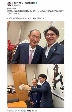 秋田県議会議員の宇佐見康人氏が2ショットを投稿した菅義偉氏。猫背気味の立ち姿勢や上手く笑顔の作れていない硬直した表情、どこを見ているのかわからない視線など、“元気”とはとても言い難いショット（宇佐美氏のXより）