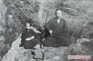 山に登り、崖を背にして、目の前には真剣を立てて座禅する『刀岳の禅』の様子