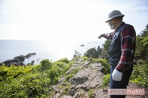 「飛び込み場所」のひとつを指さす茂さん。断崖絶壁を見下ろし、同行した編集者は思わず足がすくんだ　撮影／齋藤周造