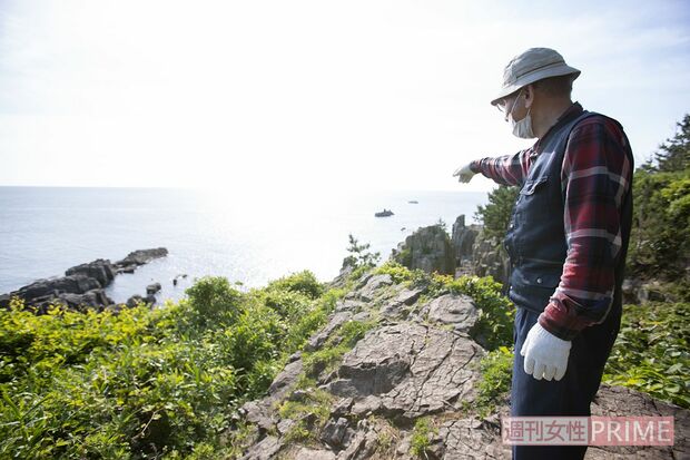 「飛び込み場所」のひとつを指さす茂さん。断崖絶壁を見下ろし、同行した編集者は思わず足がすくんだ　撮影／齋藤周造