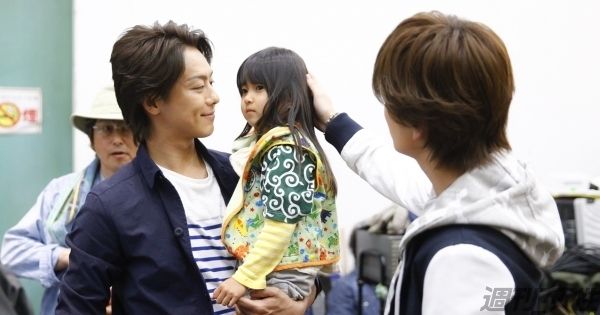 TAKAHIROが抱っこするのは、撮影で仲よくなったスタッフの４歳になる娘さん。頭をなでるのは、岩田