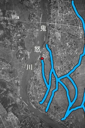  先月、豪雨で決壊した後の鬼怒川の堤防付近の昭和36年ごろの周辺状況。白丸は堤防決壊個所。写真の太線はかつての鬼怒川の支流跡。南側に後背湿地が広がり今回のマンションの土地と同じ性格。洪水に耐えられず決壊した（写真は高橋教授提供）