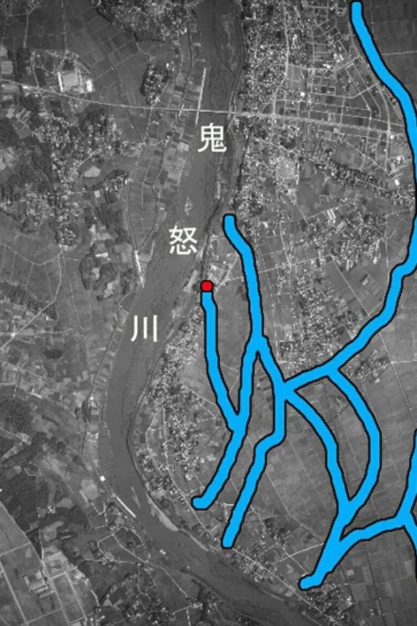  先月、豪雨で決壊した後の鬼怒川の堤防付近の昭和36年ごろの周辺状況。白丸は堤防決壊個所。写真の太線はかつての鬼怒川の支流跡。南側に後背湿地が広がり今回のマンションの土地と同じ性格。洪水に耐えられず決壊した（写真は高橋教授提供）