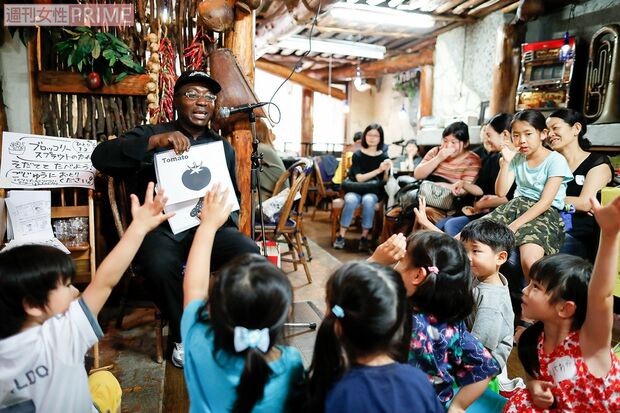 トニーさんの英語レッスン。小さい子どもも発音をまねながらクイズに参加し、「きゅうり」や「浮輪」などの英単語もスラスラ