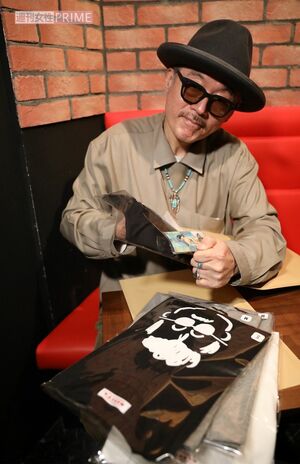 『マーシーズ』グッズを手にする田代まさし