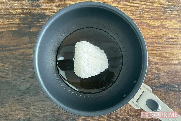 （2）サラダチキンの出汁、煮卵の出汁と塩むすびをフライパンに入れる