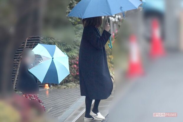 雨の中傘をさして車を待つ風間俊介の妻と長男（'19年2月）