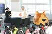 吉成館長の絵本読み聞かせ。身振り手振りで子どもたちを夢中にさせ、楽しませる。右横にあるのが、わんこカート『きらら』