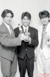シャンパンを手に20歳のお祝いを。肩パッドとすそのカットが印象的な当時流行ったデザインのスーツに身を包んだ'85年の3人