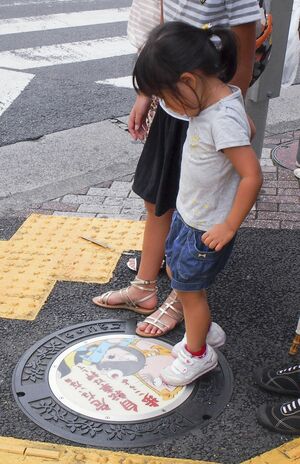 鬼太郎のキャラマンホールに興味を示す女の子（東京・調布市）　　撮影／大嶺こず恵