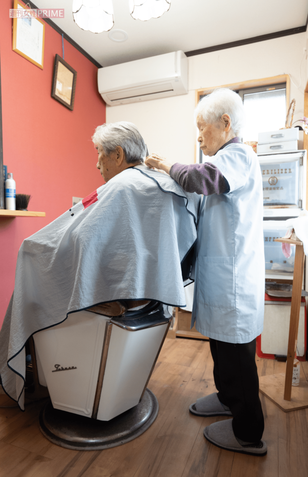 背筋をしっかり伸ばし、年齢を感じさせない集中力で髪をカットしていく(撮影/北村史成)