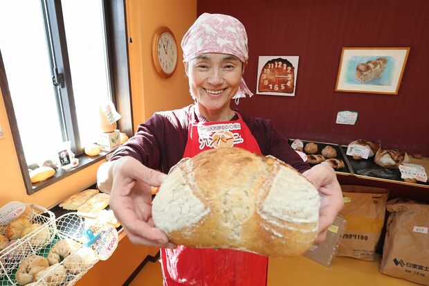 殿堂入り大食い女王・菅原初代さん。店名にもなっている自家製天然酵母を使ったパン「カンパーニュ」を手に