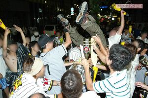 2003年9月15日、阪神タイガースの優勝を祝って胴上げをするファンたち