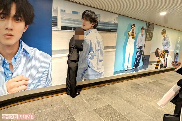 渋谷駅地下通路に展示されたKing & Prince『なにもの』巨大広告と記念撮影をするファン