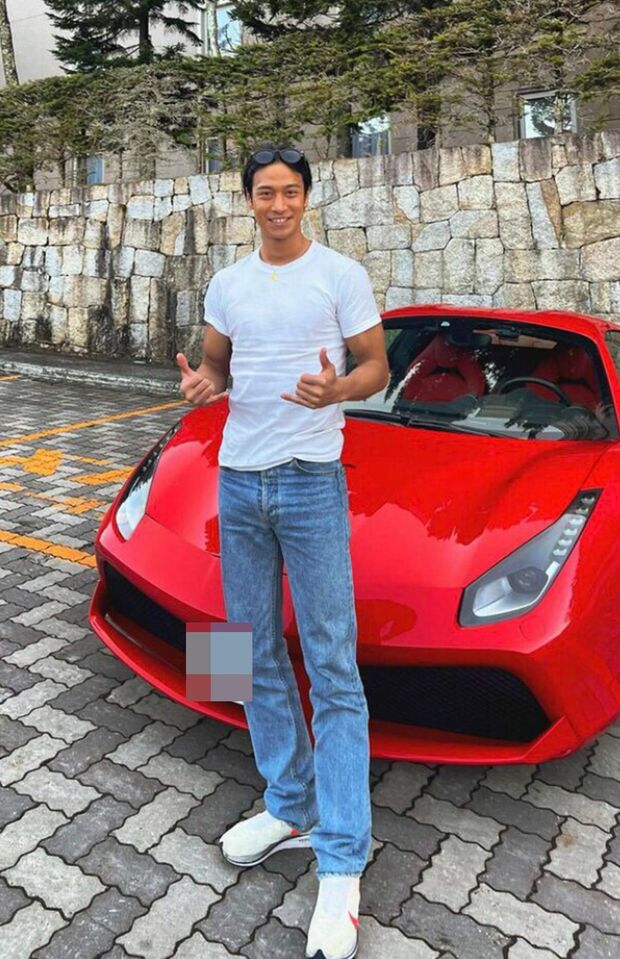 赤いフェラーリの前でポーズを決める北畠容疑者（SNSより）